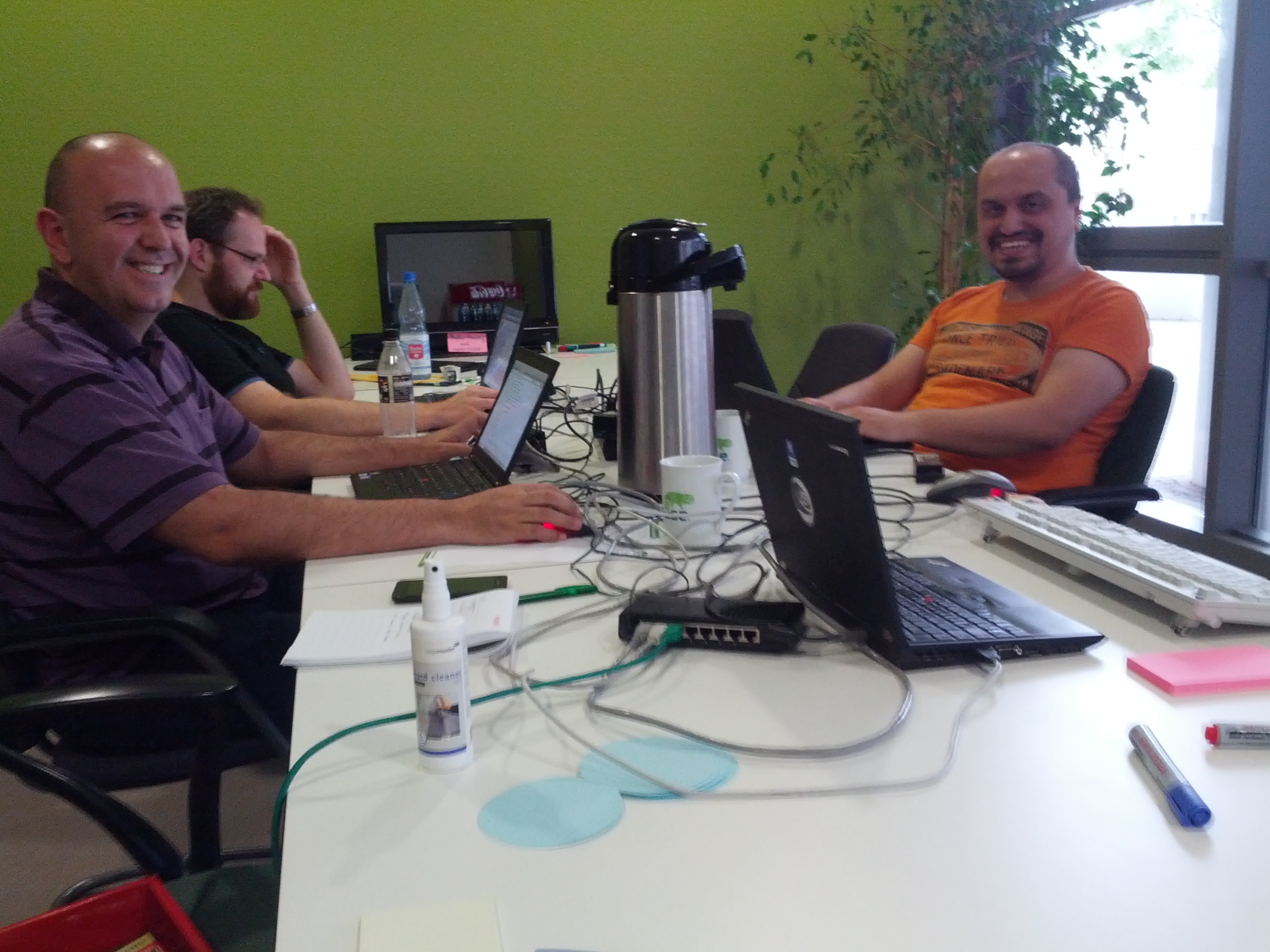 Agustin, Ismael and Christopher working around a table on openSUSE release PR